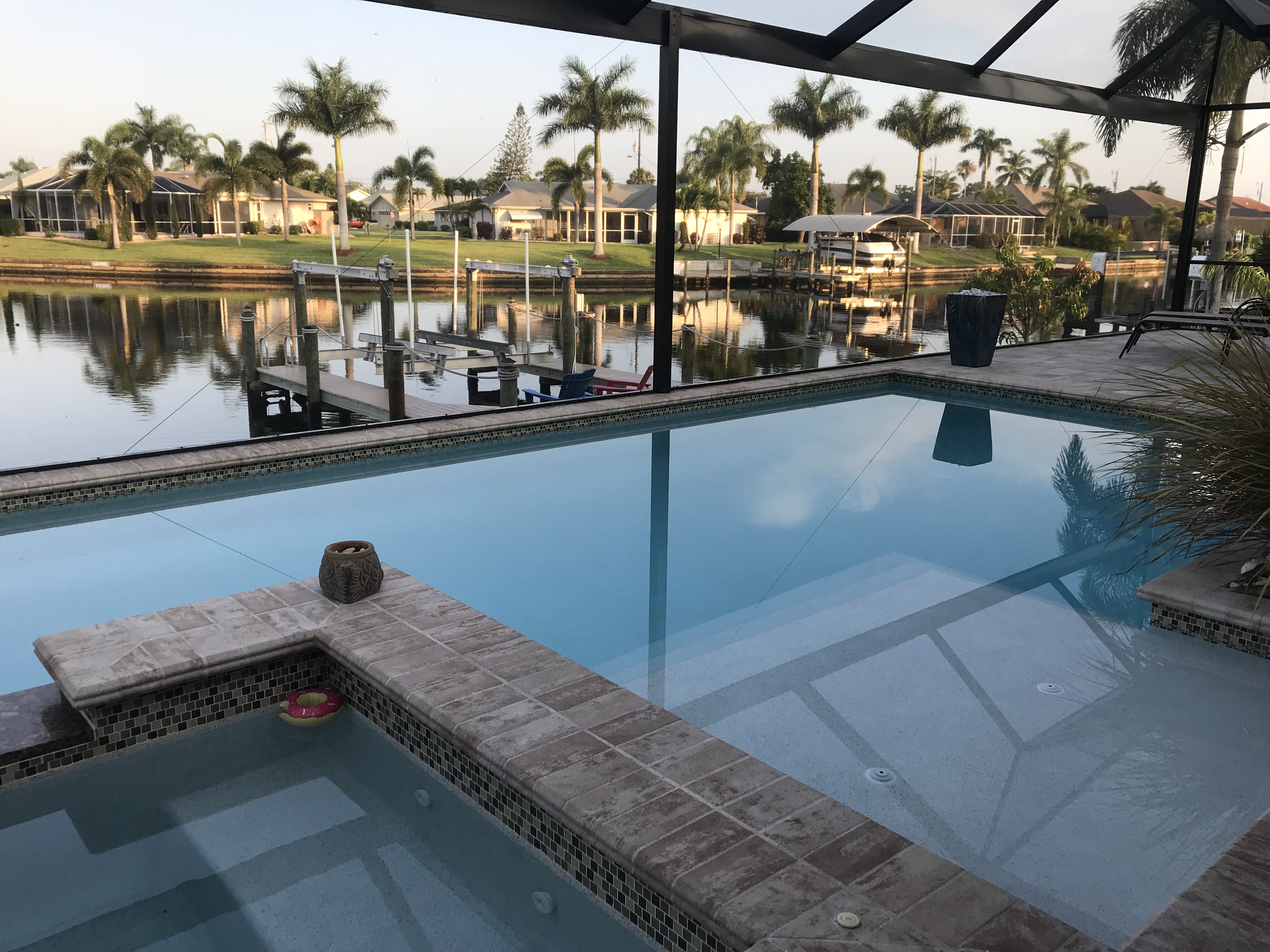 Inviting poolside backyard area of a beautiful Cape Coral, FL house, representing the competitive Florida real estate market and the advantages of learning with Cooke Real Estate School to adapt to higher mortgage rates.